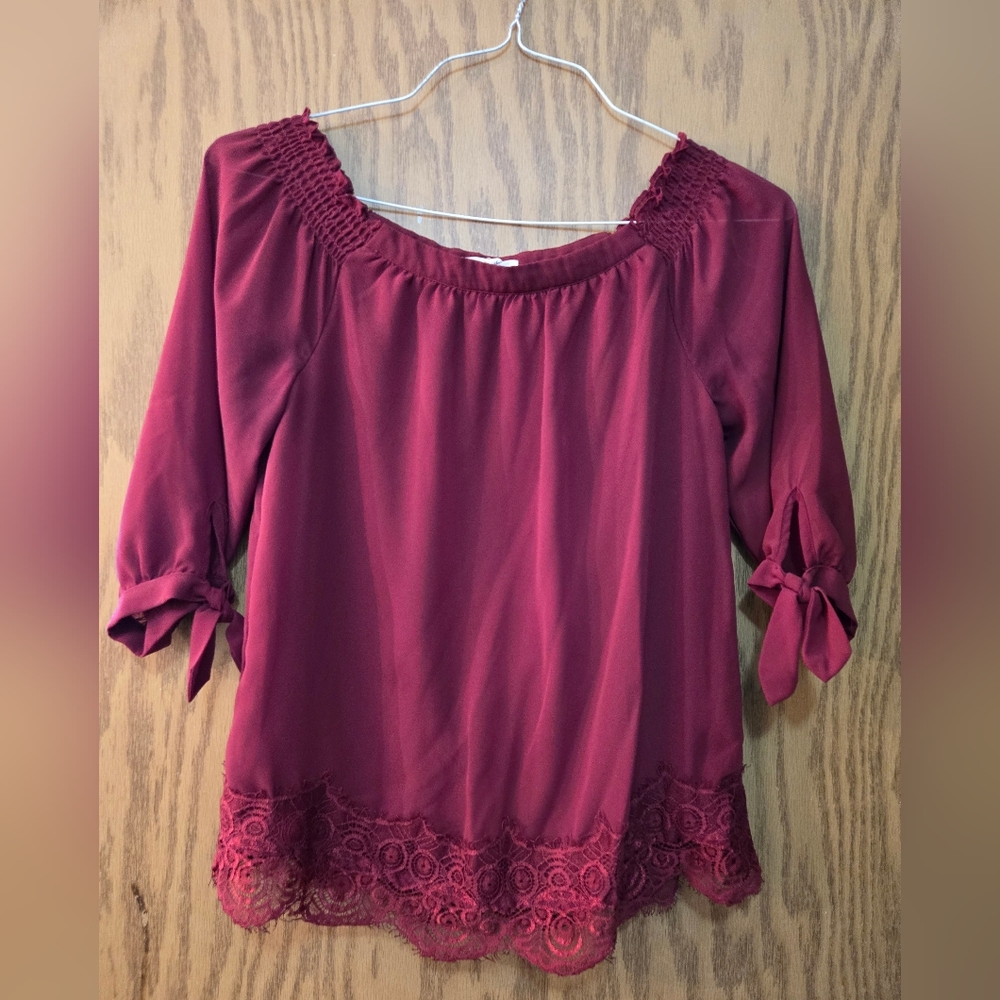 Beautiful burgundy off the shoulder blouse with 3/4 sleeves and lace trim.